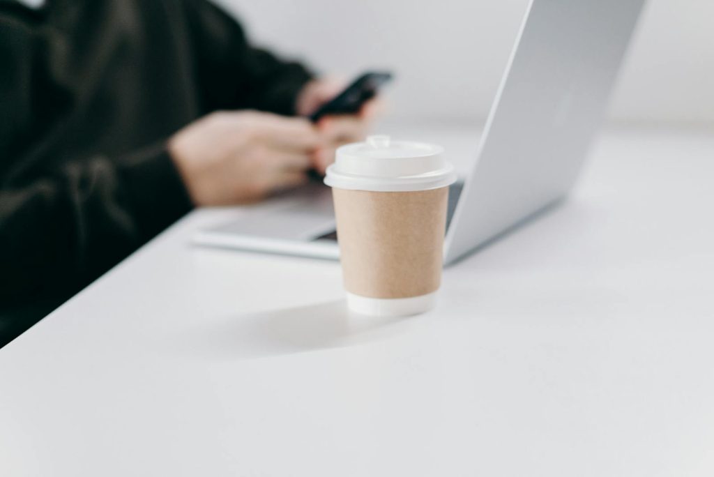 White and Brown Disposable Cup on White Table